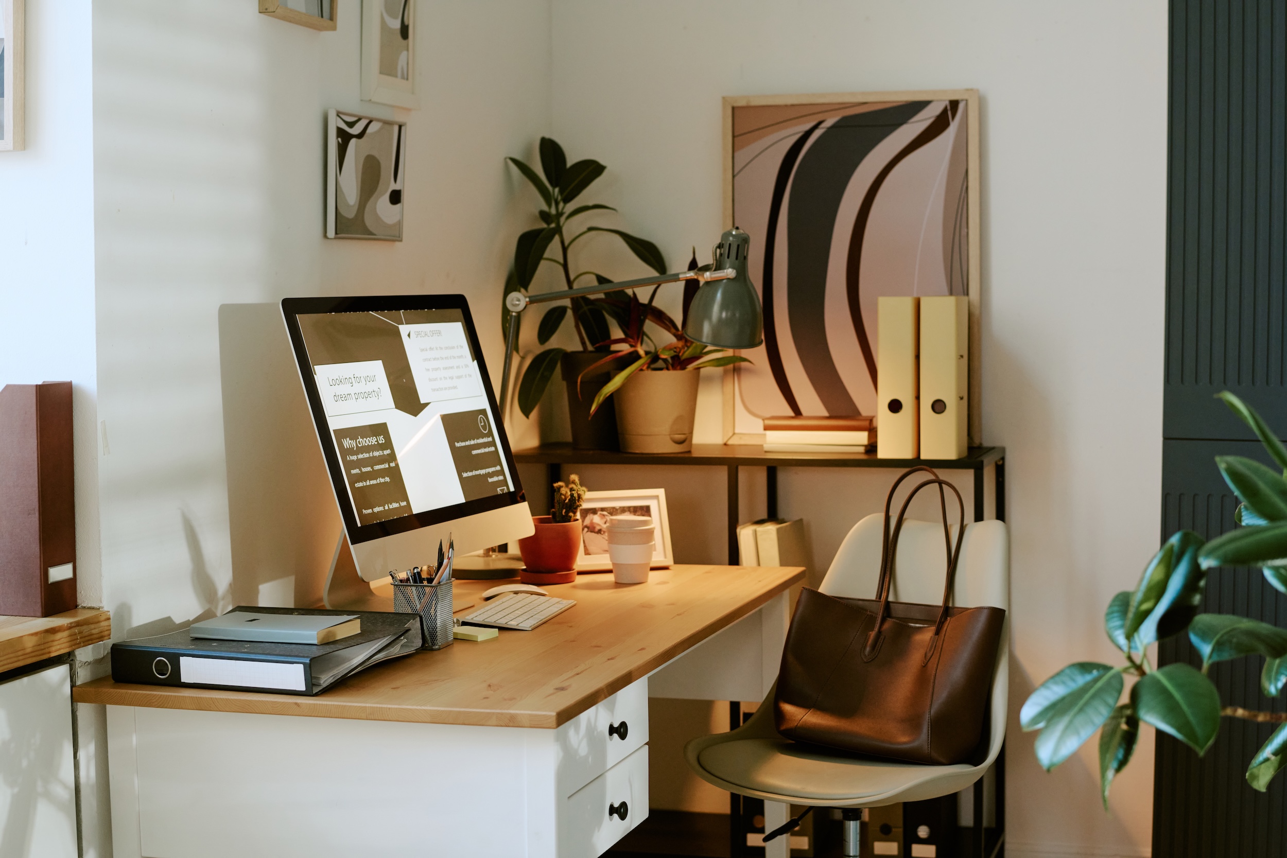 Zona de teletrabajo organizada con escritorio, ordenador y decoración minimalista en casa