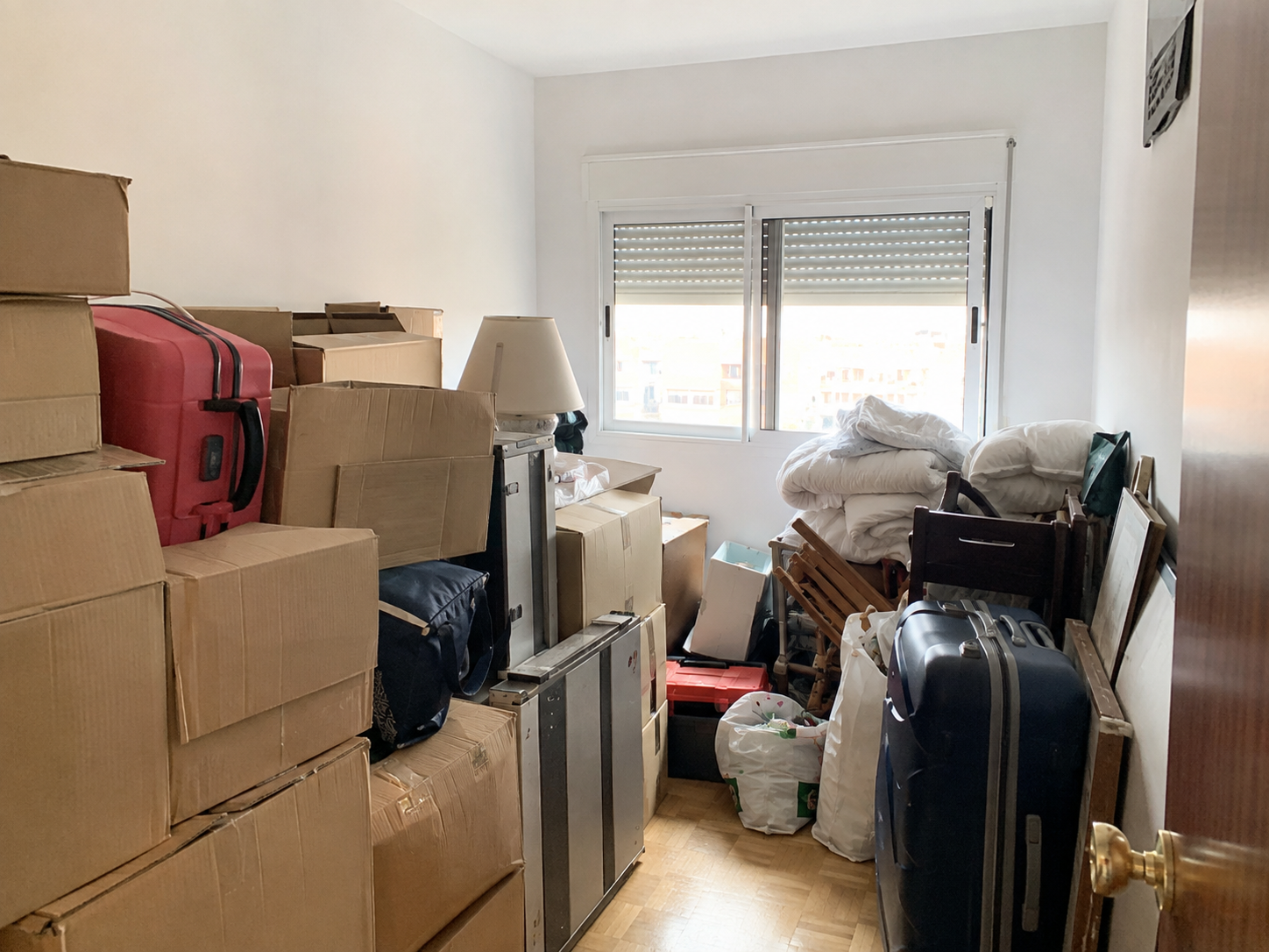 Habitación pequeña de una vivienda completamente llena de cajas de mudanza apiladas